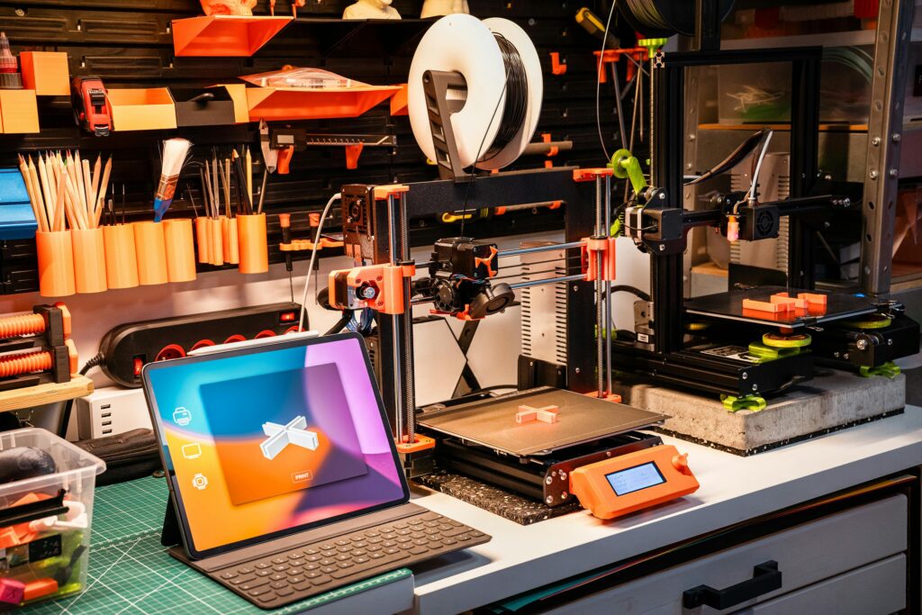 A high-tech workshop featuring 3D printers and a tablet on a desk, showcasing modern innovation.